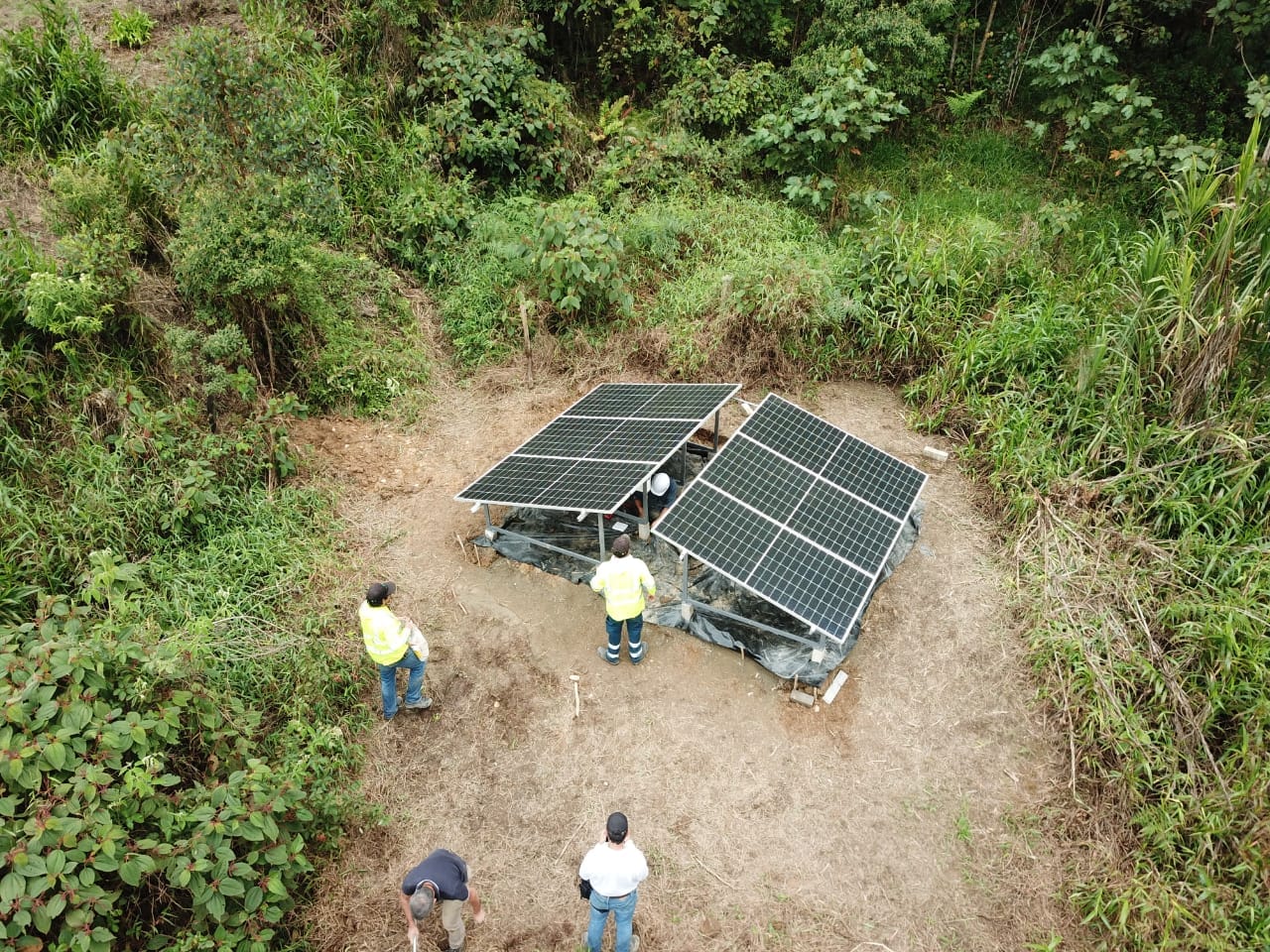 Instalación de paneles solares en suelo dentro de una finca rodeada de vegetación, vista aérea