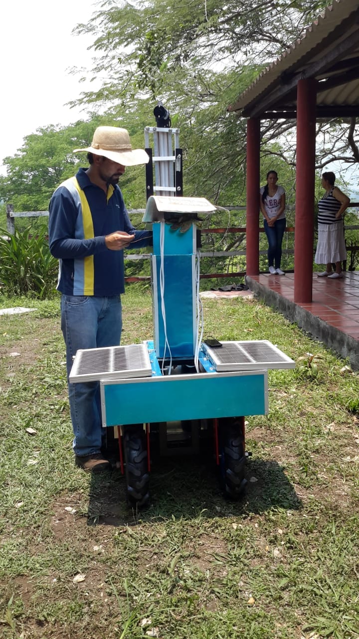 Operario junto a una máquina multipropósito azul alimentada con paneles solares
